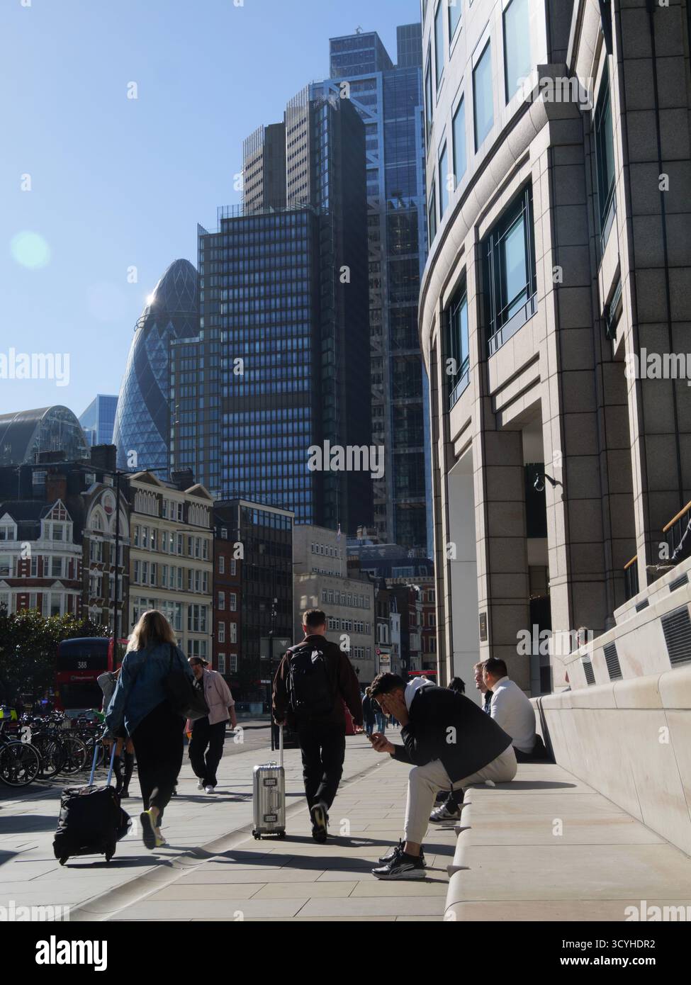 Les gens s'assoient sur des marches en béton conçues comme un coin salon public à l'extérieur de Broadgate tandis que les piétons montent Bishopsgate London en direction des gratte-ciel de la City de Londres au Royaume-Uni Banque D'Images
