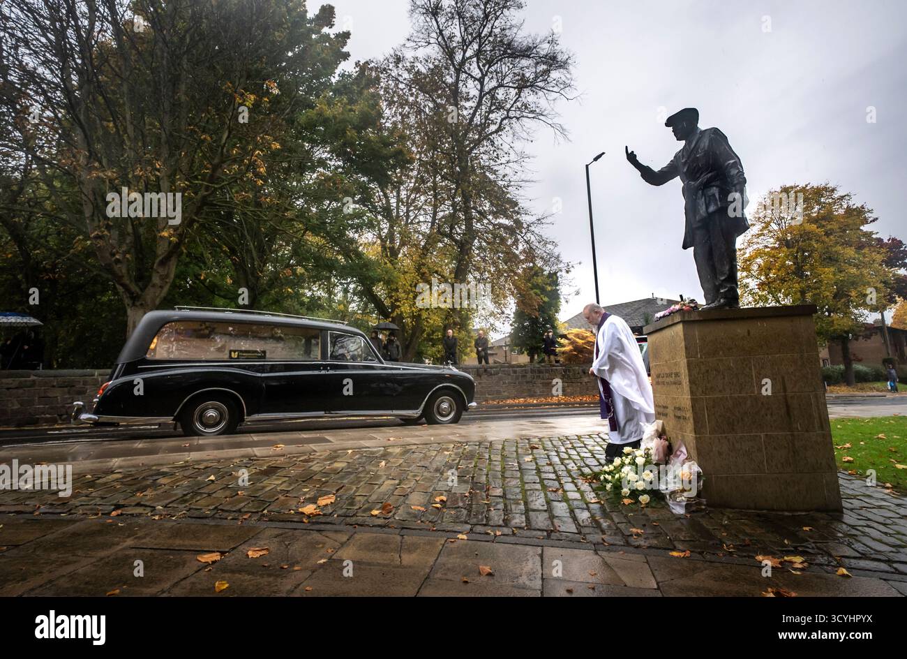 Le cortège funéraire de Dickie Bird passe devant la statue de bronze grandeur nature de Dickie Bird près de l’église St Mary, Barnsley. Date de la photo : dimanche 19 octobre 2025. L'ancien juge-arbitre Harold 'Dickie' Bird est décédé en septembre à l'âge de 92 ans. Banque D'Images