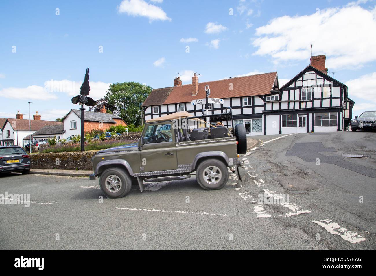 Land rover Defender et cottages à colombages noirs et blancs dans le village de Weobley, dans le Herefordshire, font partie de la piste noire et blanche. Banque D'Images