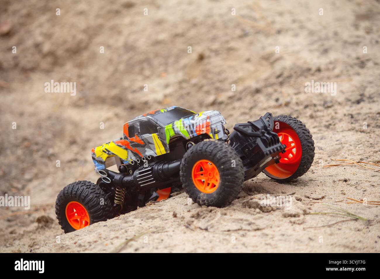Gros plan réaliste sur le sable d'escalade de voiture jouet RC hors route Banque D'Images