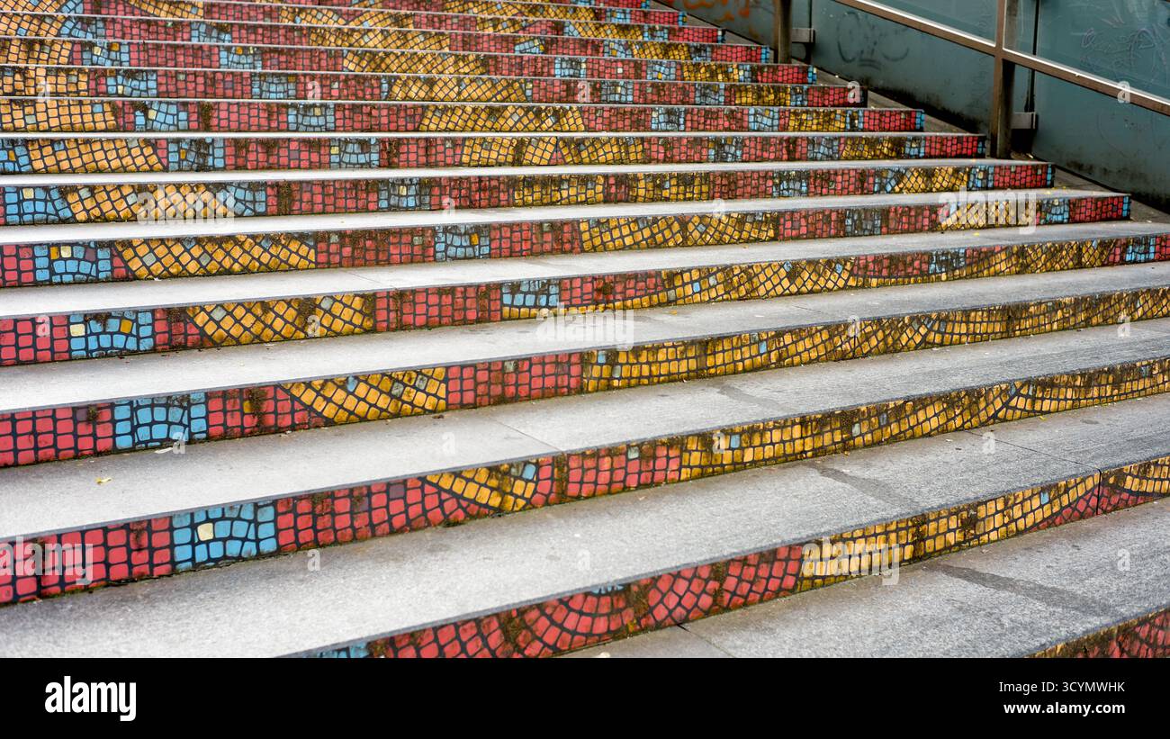 Escalier en mosaïque colorée dans la ville, avec des carreaux artistiques décorant les faces verticales de chaque marche. Banque D'Images