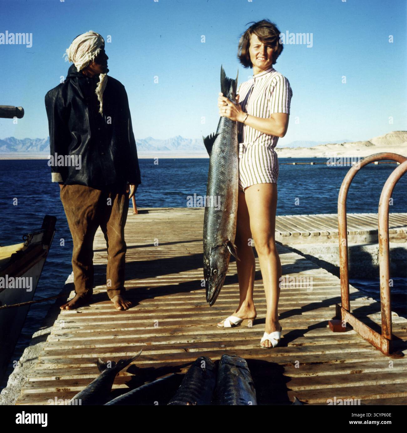 Femme et égyptien avec grand barracuda captif, grand barracuda (Sphyraena barracuda), environ 1, 40 mètres de long, mer Rouge, 1960s, Égypte Banque D'Images