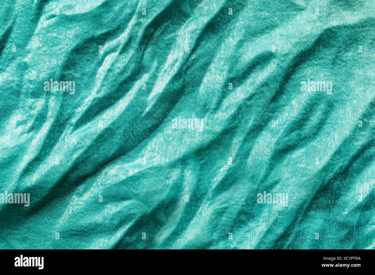 Tissu plissé de couleur turquoise de soie en gros plan comme arrière-plan Banque D'Images