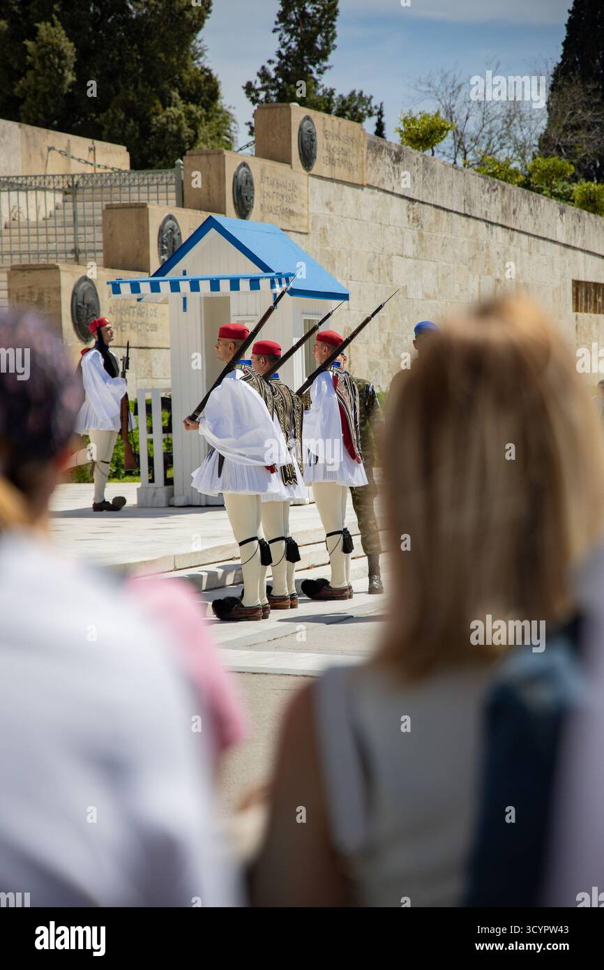 Les membres de la Garde présidentielle Evzones, portant l'uniforme traditionnel Fustanella, participent à une cérémonie de changement de garde observée par les touristes Banque D'Images