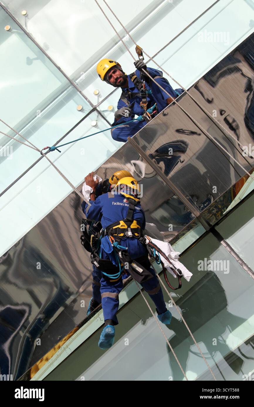 27.03.2024, Émirats Arabes Unis, , Dubaï - nettoyeurs de bâtiments sécurisés par des cordes lors du nettoyage d'un faÁade en verre. 00S240327D060CAROEX.JPG [AUTORISATION DU MODÈLE : Banque D'Images