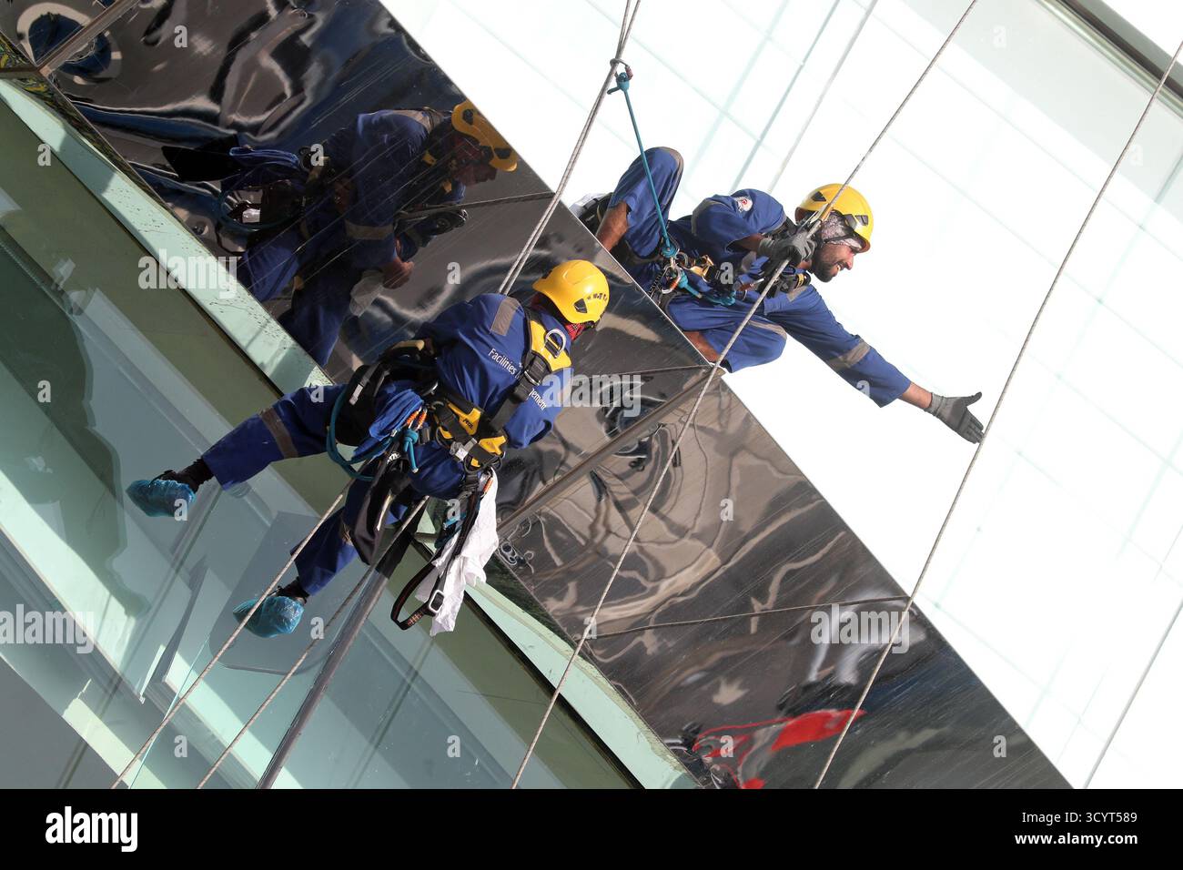 27.03.2024, Émirats Arabes Unis, , Dubaï - nettoyeurs de bâtiments sécurisés par des cordes lors du nettoyage d'un faÁade en verre. 00S240327D058CAROEX.JPG [AUTORISATION DU MODÈLE : Banque D'Images