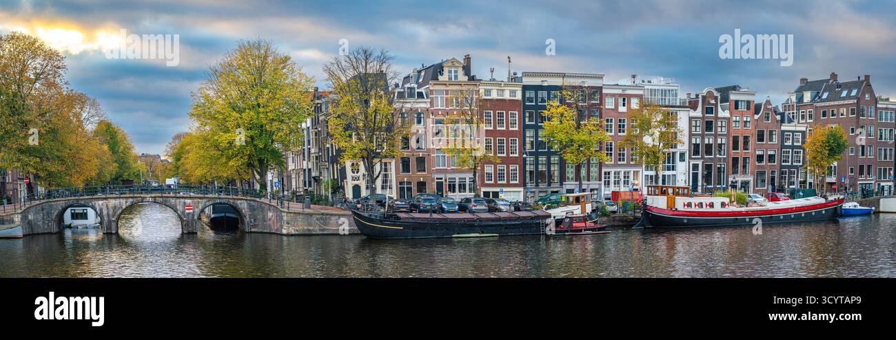 Panorama d'Amsterdam en automne, front de mer de la rivière Amstel avec des maisons hollandaises pittoresques au coucher du soleil Banque D'Images