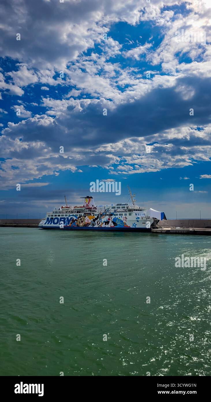 Un ferry Moby Lines dans le port de Toscane. En arrière-plan - ciel bleu et nuages blancs, au premier plan brillante mer émeraude. 28 septembre 2024 Banque D'Images