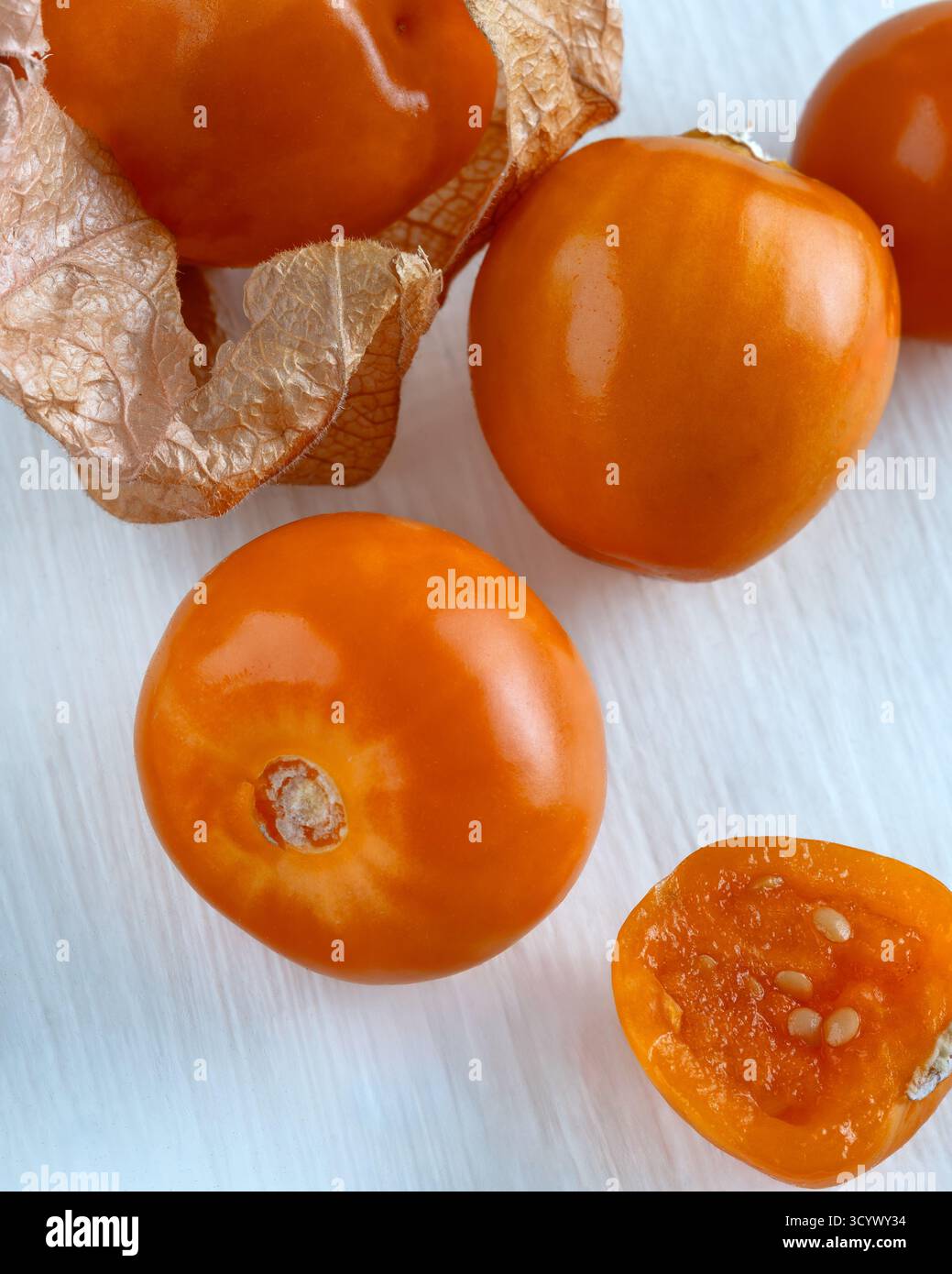 Gros plan de baies dorées fraîches, également connues sous le nom de physalis ou cerises moulues, placées sur un fond blanc. Banque D'Images