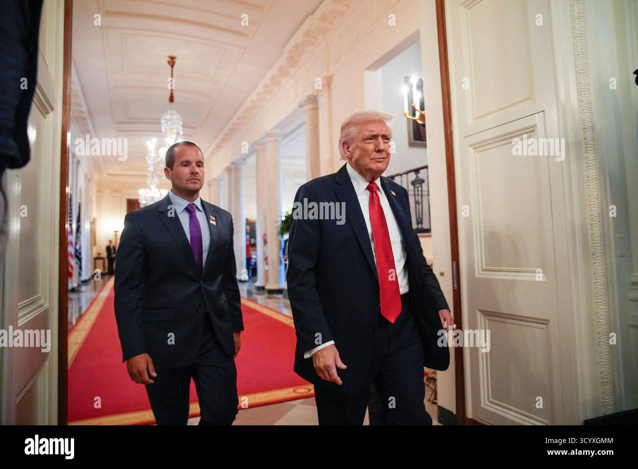 Washington DC, États-Unis. 20 octobre 2025. Le président AMÉRICAIN Donald Trump, flanqué de Brad Neffendorf, entraîneur-chef des pilotes LSU Shreveport, à gauche, arrive pour participer à une visite avec les champions de baseball LSU et LSU Shreveport dans la salle est de la Maison Blanche à Washington, DC, USA, le 20 octobre 2025. Photo de Yuri Gripas/ABACAPRESS.COM crédit : Abaca Press/Alamy Live News Banque D'Images