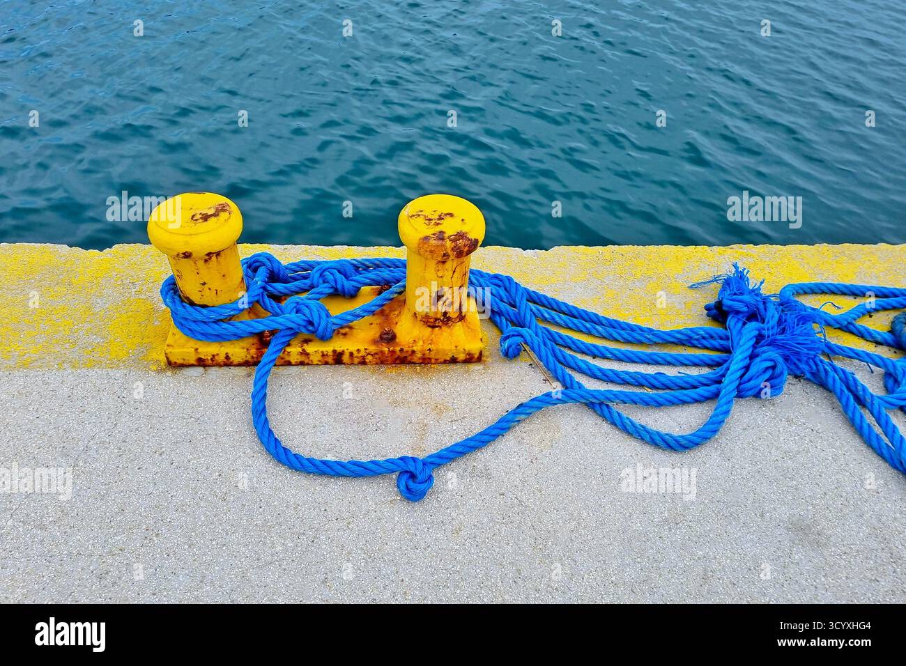 Une corde d'amarrage et une borne aux couleurs du drapeau ukrainien à un quai sur l'île de Céphalonie, en Grèce Banque D'Images