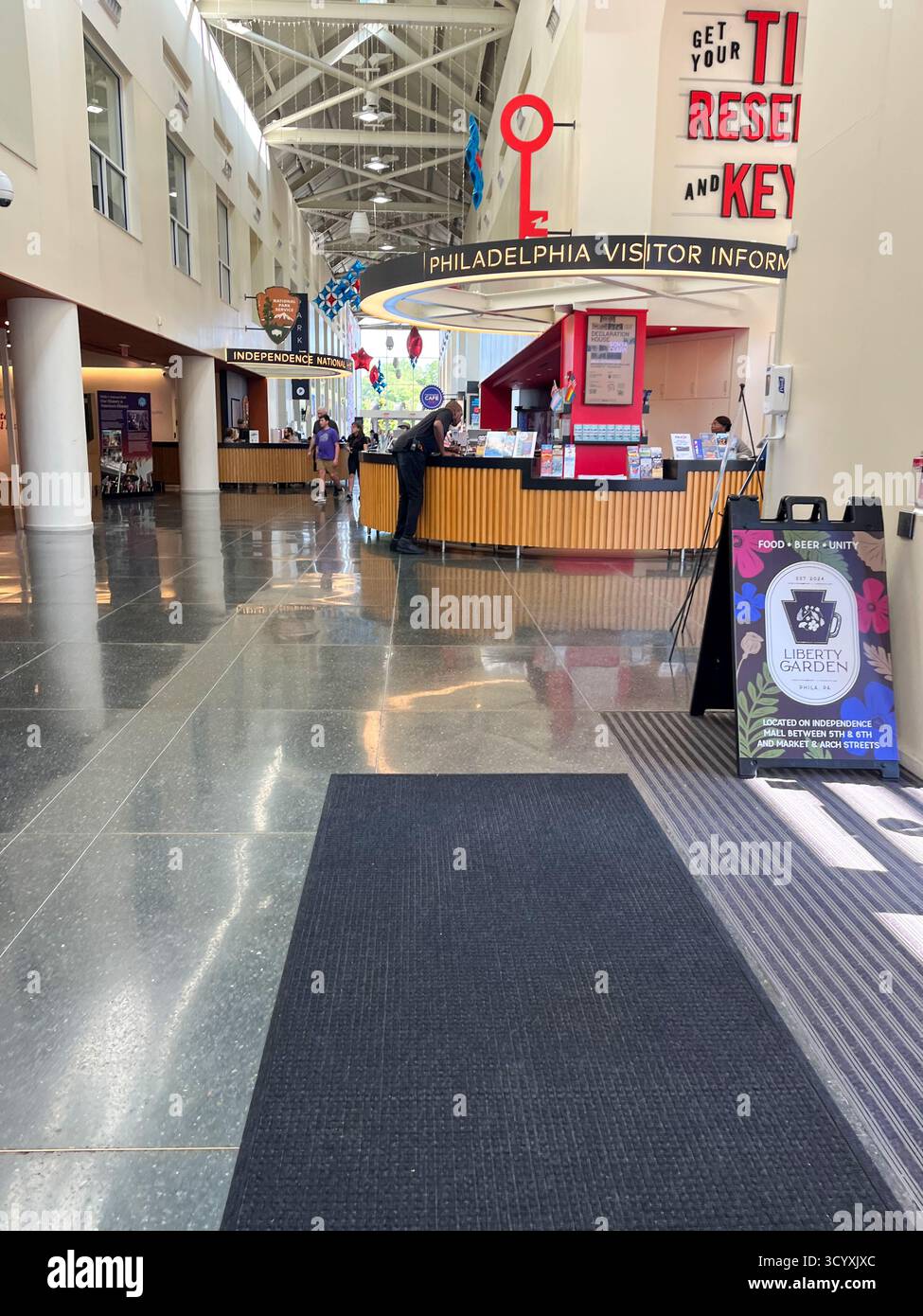 Un grand hall d'entrée avec un panneau qui dit "Get Your 11 :11 Reset Key". Il y a plusieurs personnes qui marchent autour de la région Banque D'Images Un grand hall d'entrée avec un panneau qui dit "Get Your 11 :11 Reset Key". Il y a plusieurs personnes qui marchent autour de la région Banque D'Images