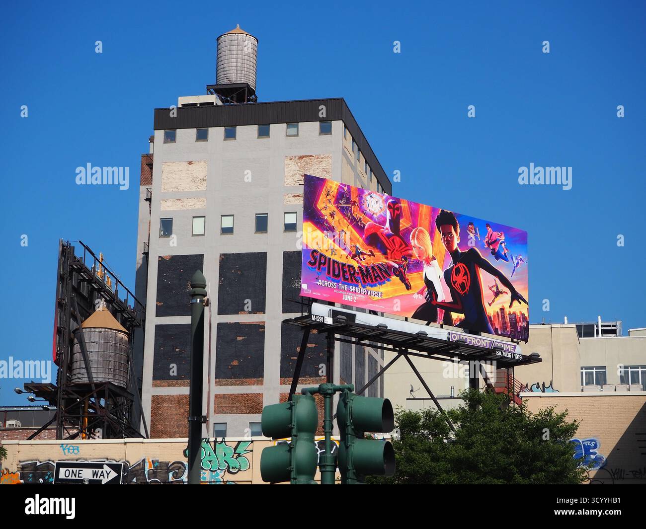 Spider-Man à travers le panneau d'affichage Spider-verse lors d'une journée ensoleillée à New York City avec ciel bleu et château d'eau Banque D'Images