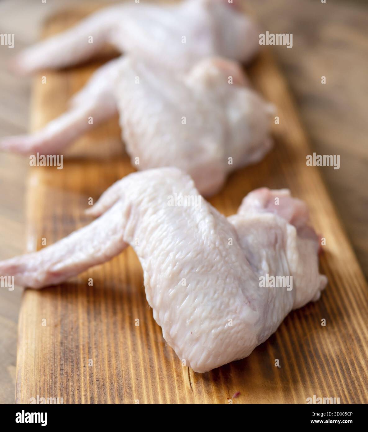 Ailes de poulet sur une planche de bois Banque D'Images