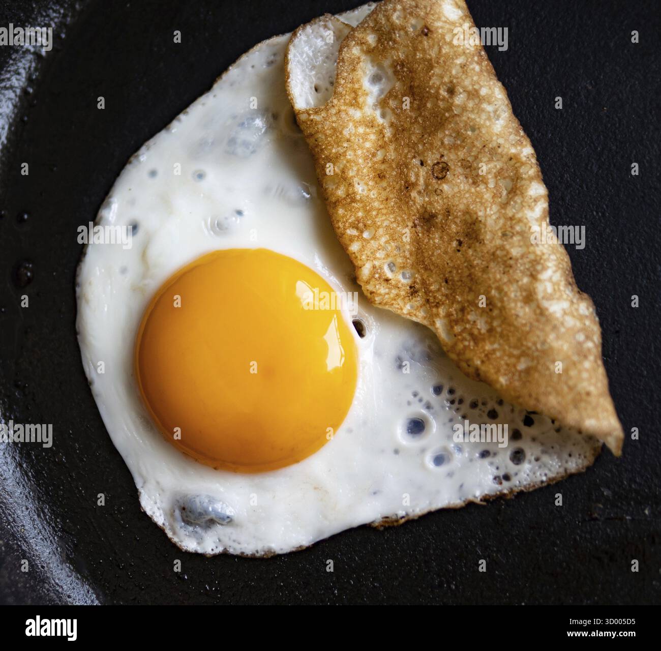 Oeuf frit dans une poêle en fonte Banque D'Images