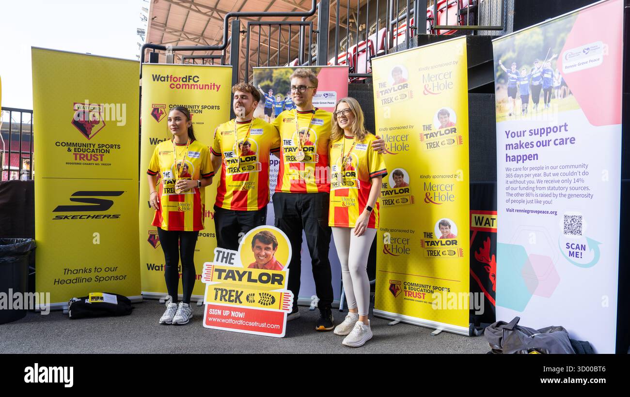 Quatre participants au Watfrod FC Taylor Trek en maillots de supporters ont été photographiés au Vicarage Rd Ground Banque D'Images