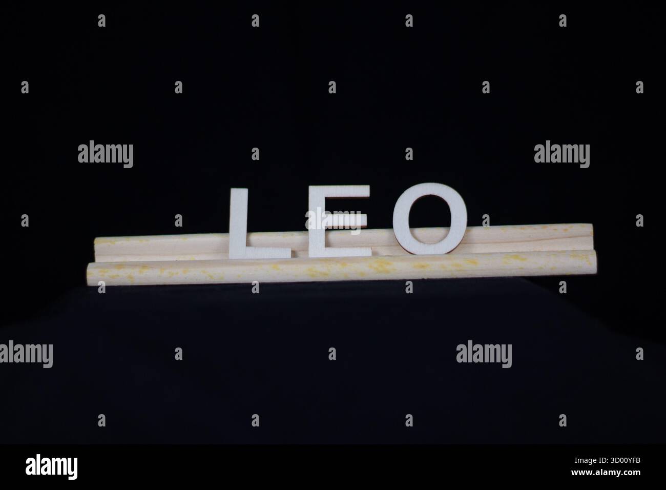 Nom de garçon traditionnel Leo en lettres en bois Unies sur un support de tuiles isolé sur un fond noir Banque D'Images