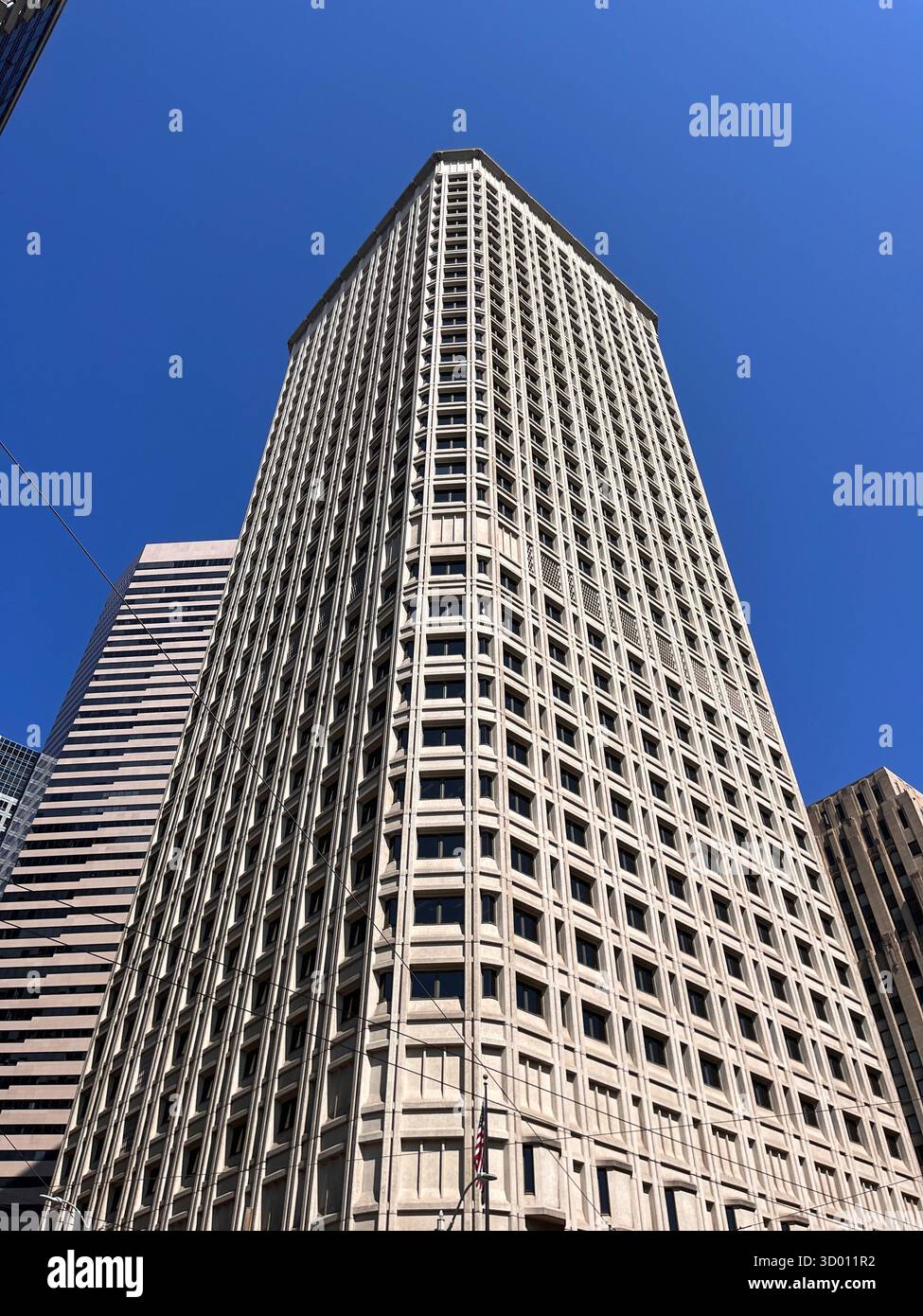 Gratte-ciel blanc moderne placé contre un ciel bleu clair, mettant en valeur l'architecture urbaine. - Image de stock capturée avec un smartphone