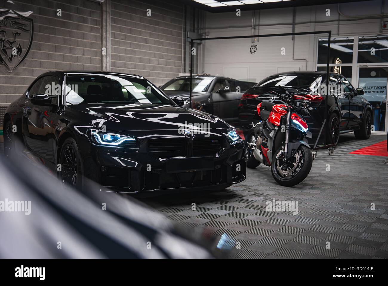 BMW M2 et Ducati moto dans un atelier de performance moderne Banque D'Images