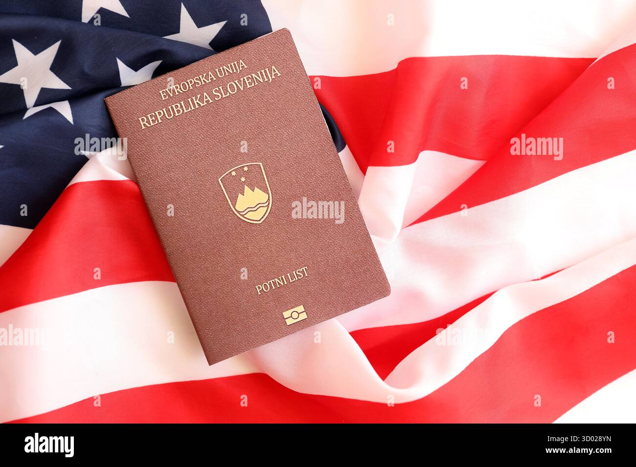 Passeport slovène sur grand drapeau agitant des États-Unis d'Amérique close up. Visa AMÉRICAIN et concept d'immigration Banque D'Images