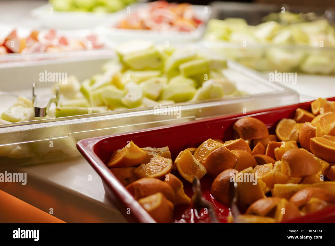 Une sélection vibrante de fruits frais est magnifiquement préparée au buffet, avec des tranches d'orange, des melons et des agrumes. Le présentoir invite les clients Banque D'Images