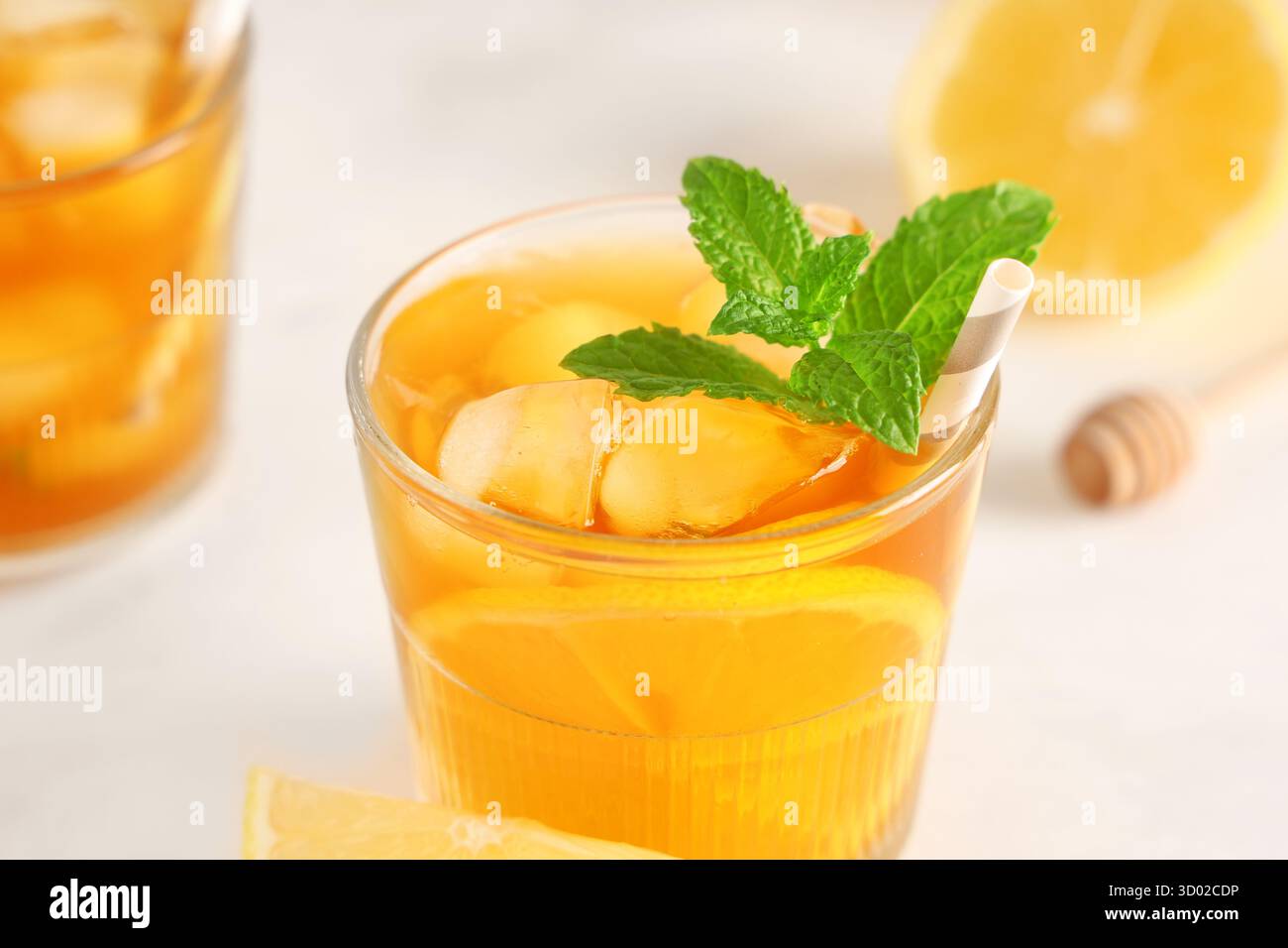 Verre de thé aux fruits avec des feuilles de citron et de menthe sur fond clair Banque D'Images