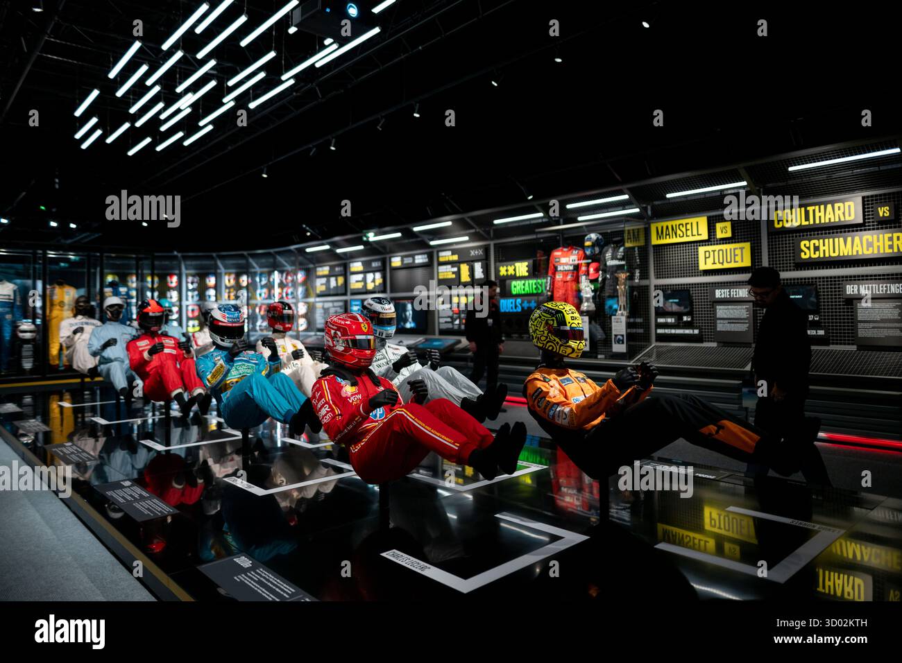 Oberhausen, Allemagne. 21 octobre 2025. Diverses combinaisons de course sont exposées. Plus de 3 000 mètres carrés d'espace à l'OBEX Oberhausen Expo vous offriront un aperçu du monde de la course. À partir du 22 octobre, le champion du monde Ferrari F1-2000 de Michael Schumacher sera exposé. Crédit : Fabian Strauch/dpa/Alamy Live News Banque D'Images