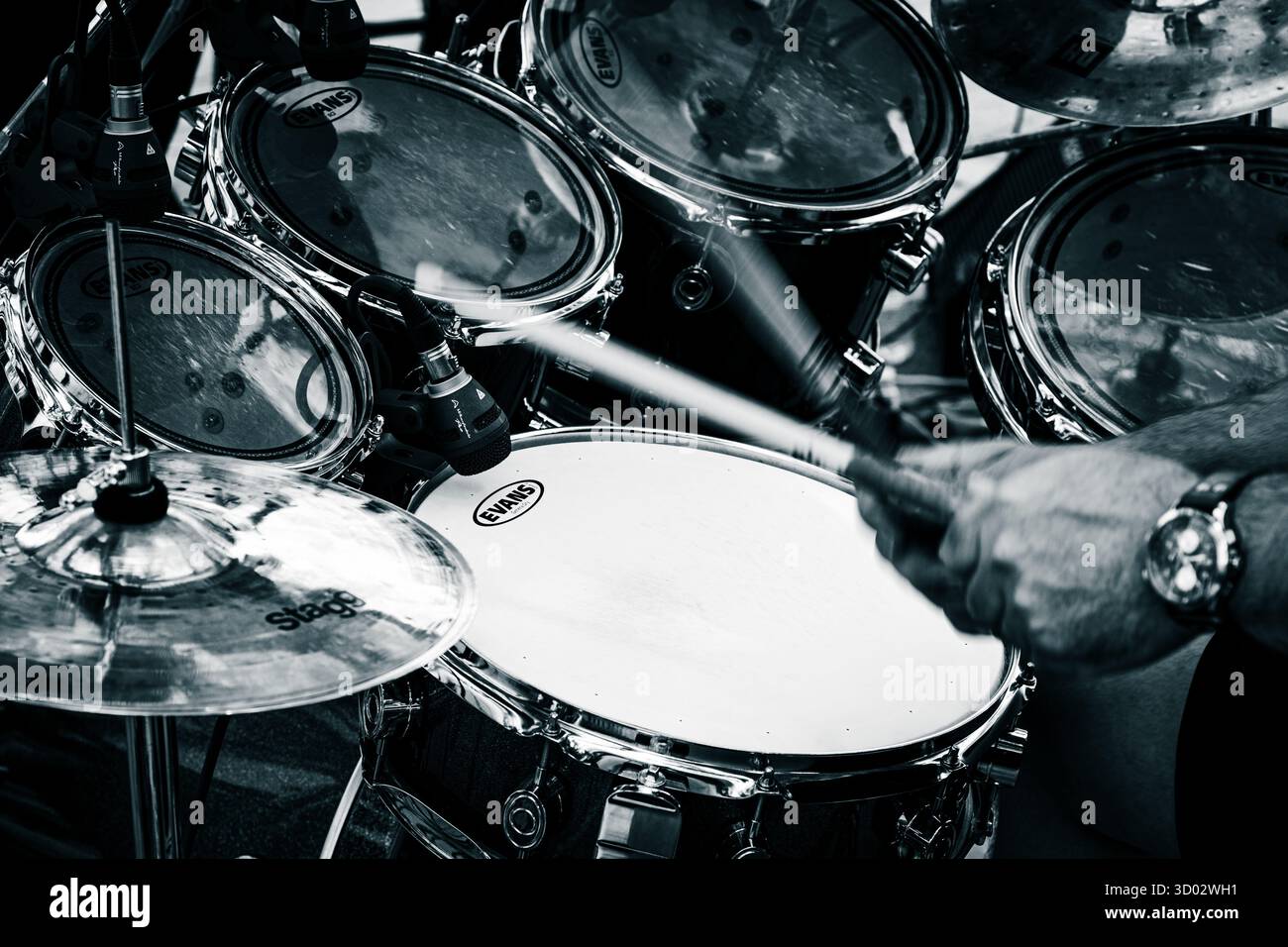 Représentation dynamique en noir et blanc d'un batteur jouant un kit avec un effet de flou dynamique pour capturer l'intensité. Banque D'Images