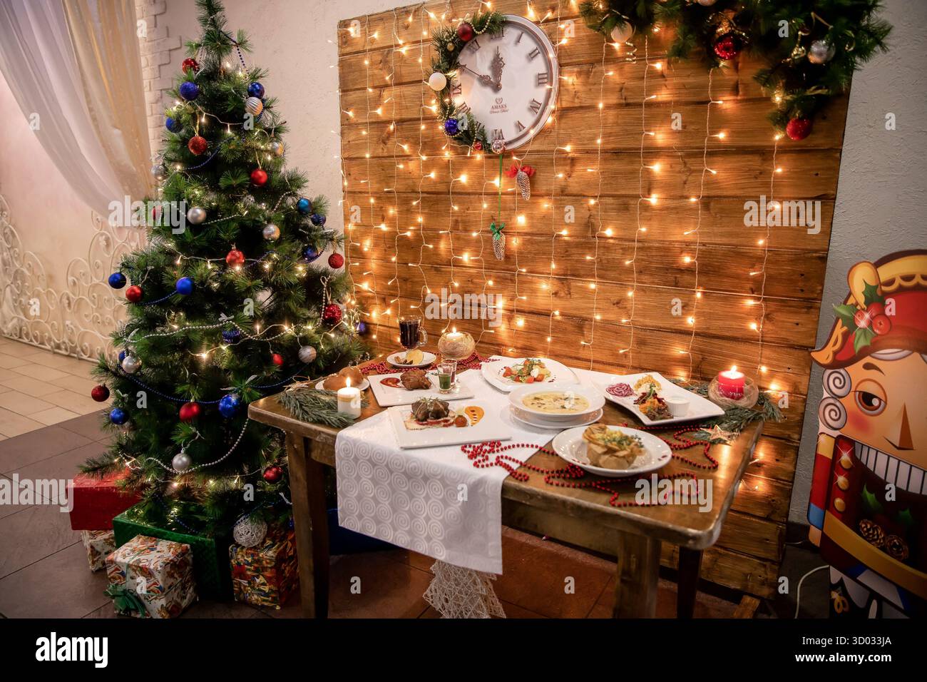 Intérieur de Noël avec arbre décoré, table de vacances et guirlande lumineuse chaude. Banque D'Images