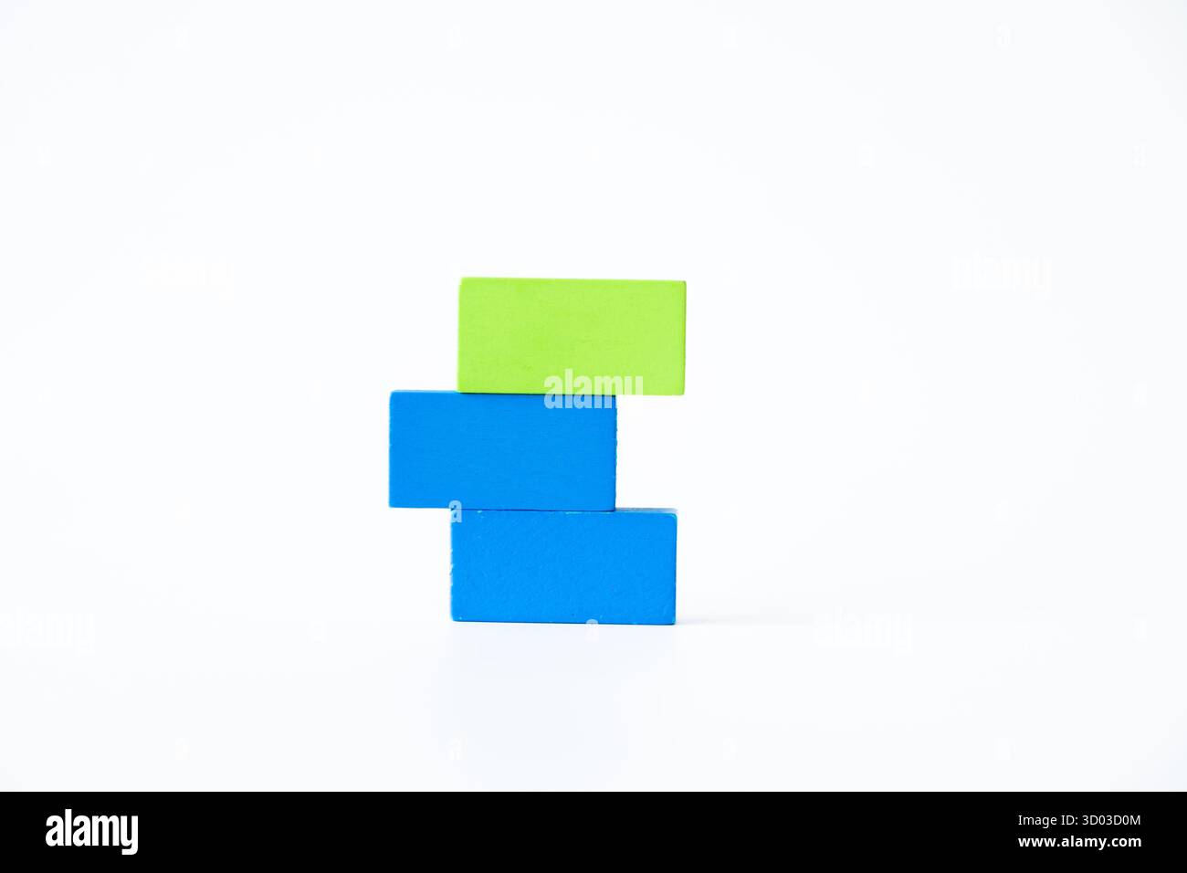 Trois rectangles en bois colorés en bleu et vert empilés verticalement sur un fond blanc, soulignant la simplicité, l'apprentissage et la desig minimale Banque D'Images