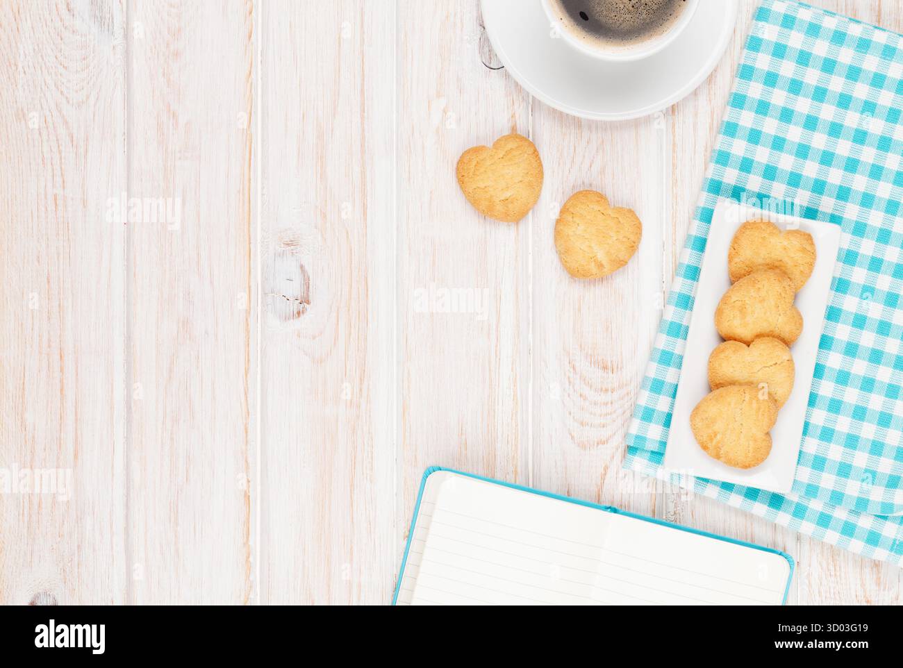 Café, biscuits en forme de coeur et le bloc-notes sur la table en bois blanc, avec copie espace Banque D'Images