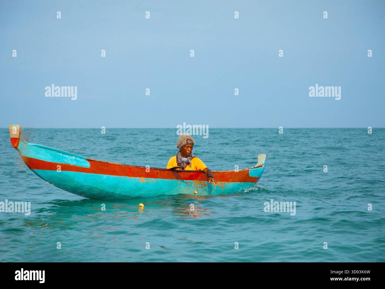 Morondava, Madagascar. 18 octobre 2023. Pêcheur malgache sur le vieux bateau pirogue en bois fait maison dans l'océan attrape des poissons avec filet. mise au point sélective, vue rapprochée depuis l'océan Banque D'Images