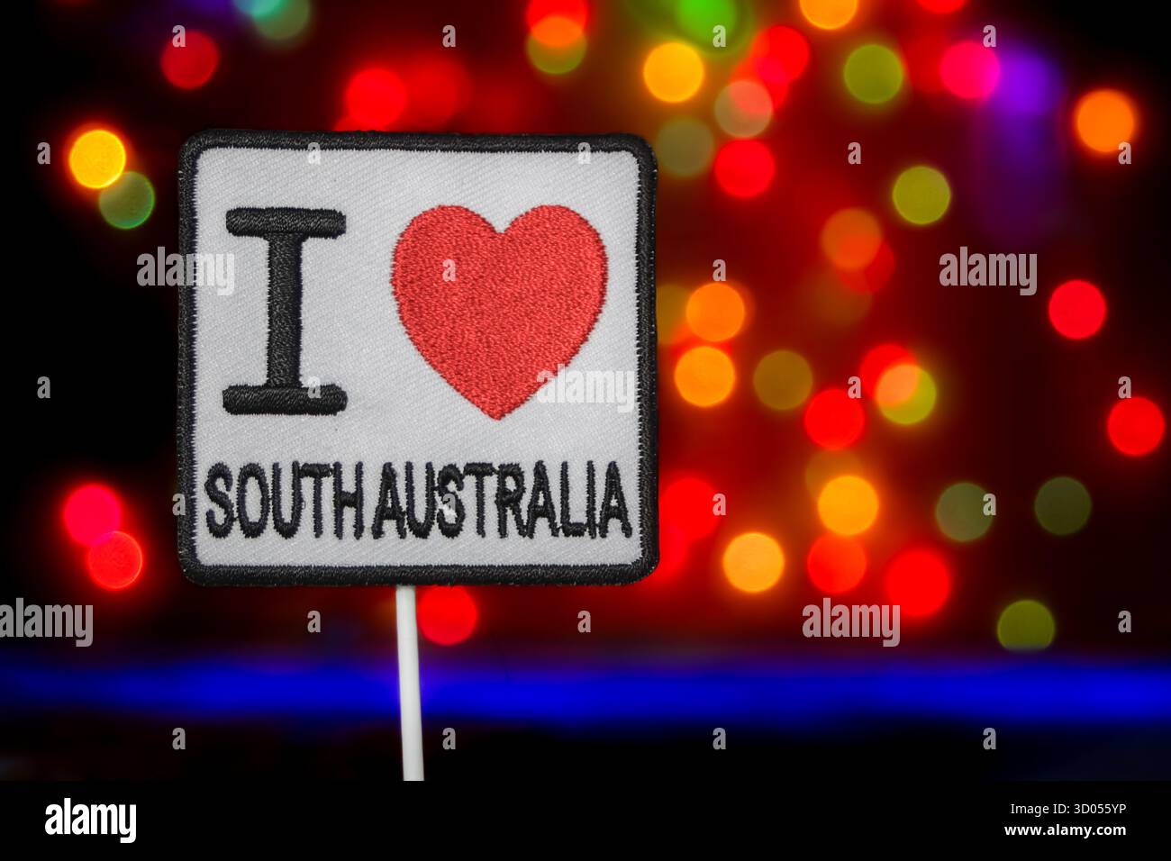 Signe « I Love South Australia » brodé sur des lumières bokeh colorées. Voyages australiens, tourisme régional et promotion festive. Banque D'Images
