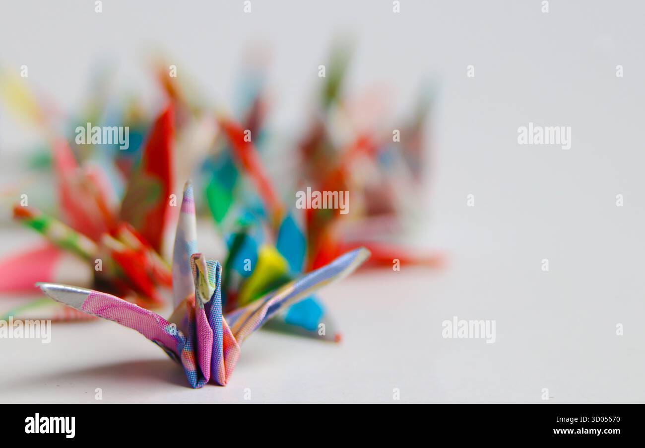 Grue unique en origami japonais vibrant avec fond bokeh doux et espace de copie vide. Symbolise l'espoir, la résilience et la concentration personnelle. Banque D'Images