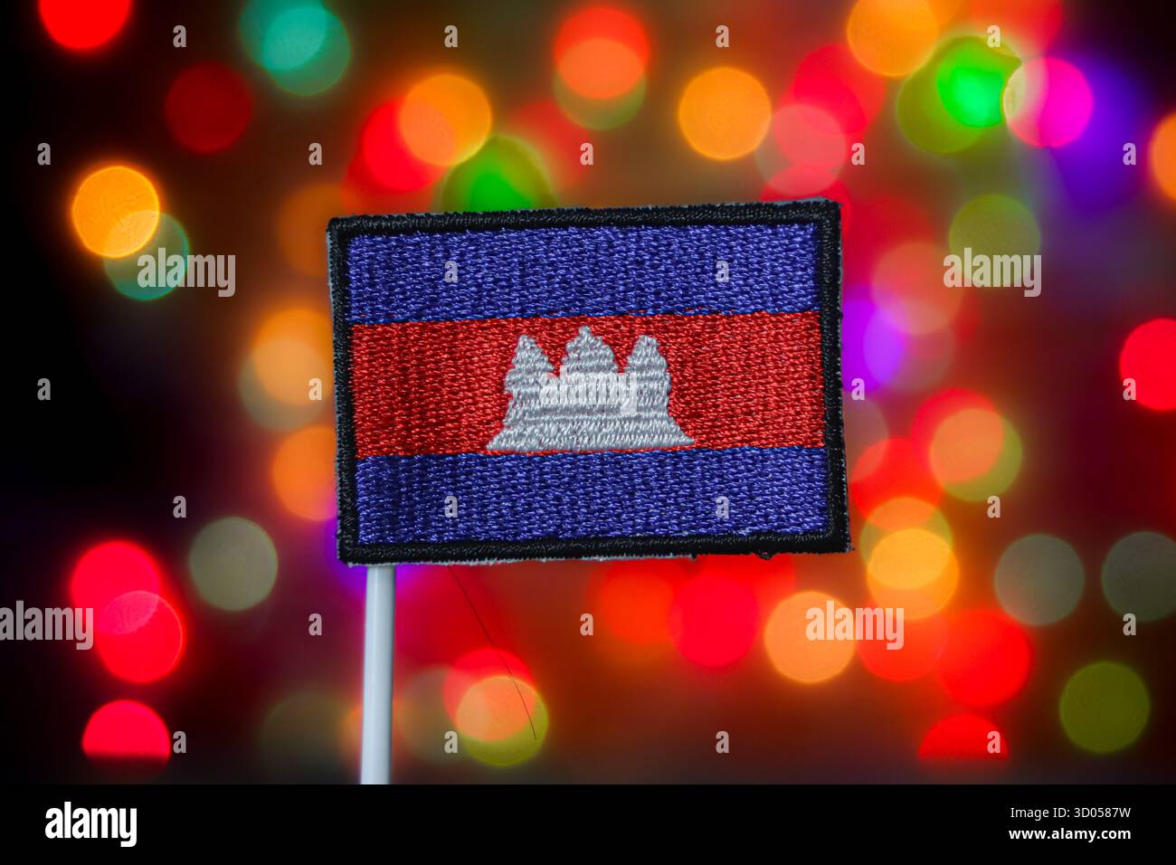 Drapeau national du Cambodge (symbole Angkor Wat) contre des lumières bokeh colorées. Voyage en Asie du Sud-est, fierté nationale et médias de vacances. Banque D'Images