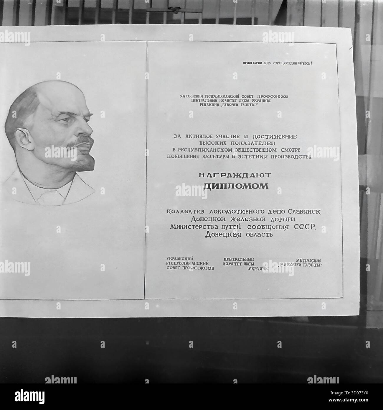 Une macro-photo détaillée d'un diplôme de l'ère soviétique pour le dépôt de locomotives de Slavyansk, années 1970-1980 Archive photo en noir et blanc, URSS, RSS d'Ukraine. Le document, décerné au collectif du dépôt, présente un grand portrait de Vladimir Lénine et le slogan communiste « prolétariens de tous les pays, Unis ! ». Il a été publié par les syndicats ukrainiens et Komsomol pour « les grandes réalisations dans l'amélioration de la culture et de l'esthétique de la production ». Cet artefact montre la propagande soviétique, la typographie et la reconnaissance officielle. Un document de la vie industrielle pacifique dans le Donbass avant la guerre. Banque D'Images
