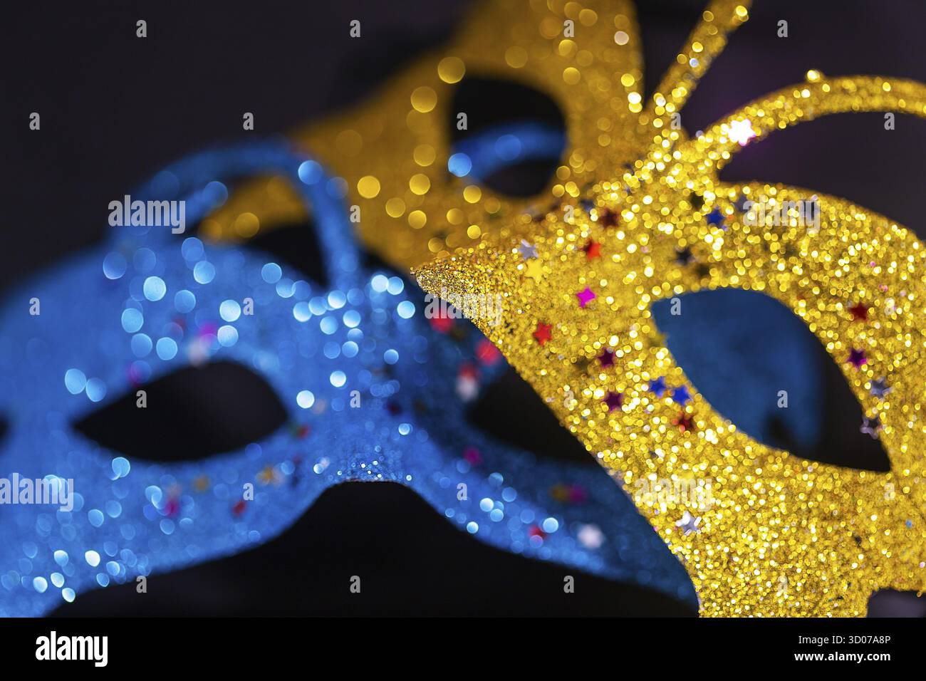 Masque de carnaval vénitien brillant jaune et bleu isolé sur fond noir. La fête du nouvel an, cachez votre visage. Gros plan Banque D'Images