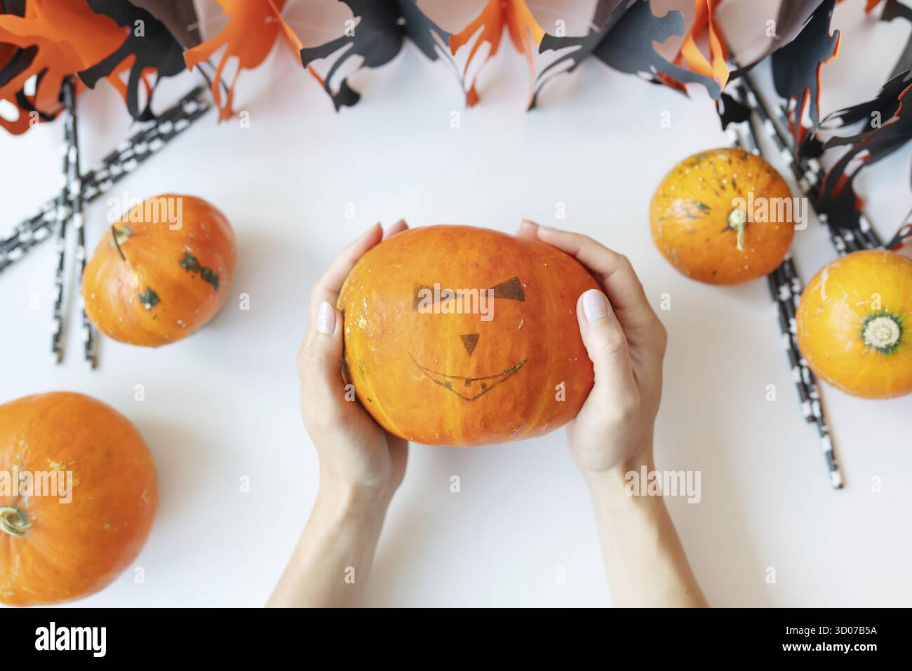 Octobre 31.Fête d'Halloween.La fille tient le visage sculpté d'une citrouille dans ses mains.Vue de dessus Banque D'Images