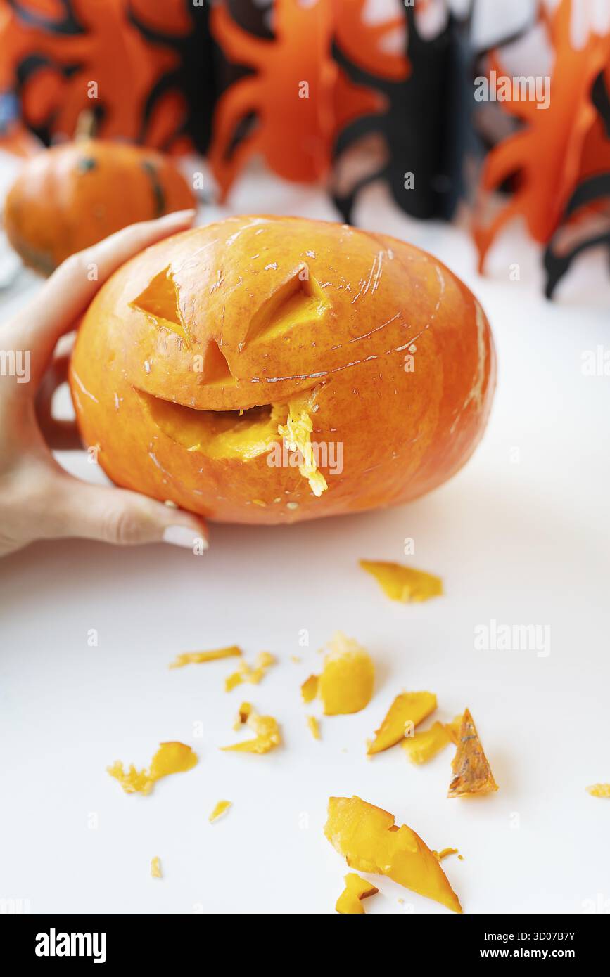 Octobre 31.Fête d'Halloween.Le visage sculpté d'une citrouille sur fond orange et noir Banque D'Images
