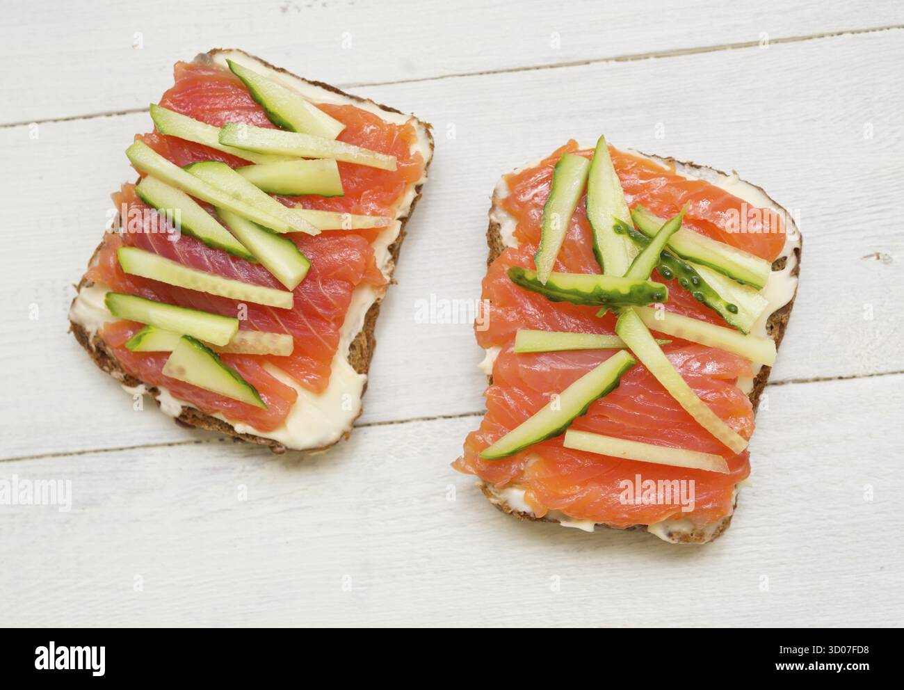 Deux sandwiches avec du poisson rouge et le concombre sur fond de bois Banque D'Images