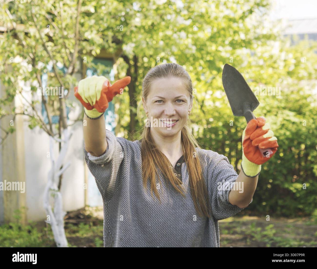 Jeune belle femme jardinière avec le pouce vers le haut Banque D'Images