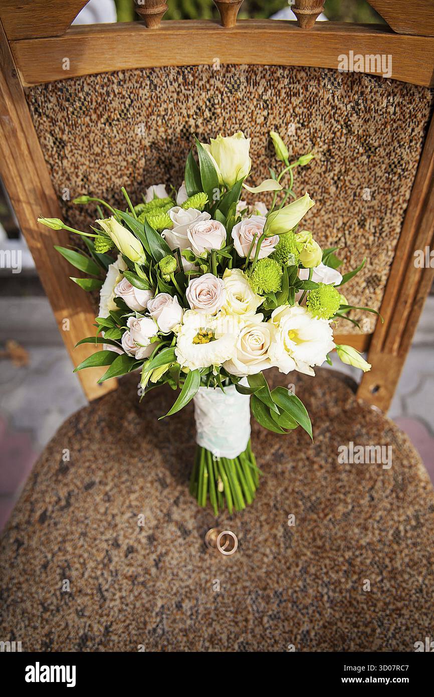 Bague et beau bouquet de fleurs différentes sur une chaise Banque D'Images
