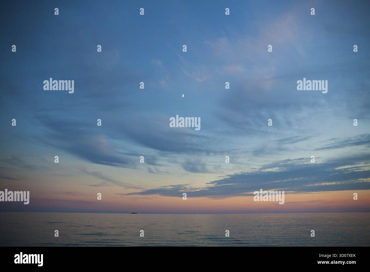 Mer et ciel au coucher du soleil. Beau paysage. Mois dans le ciel et bateau au loin Banque D'Images