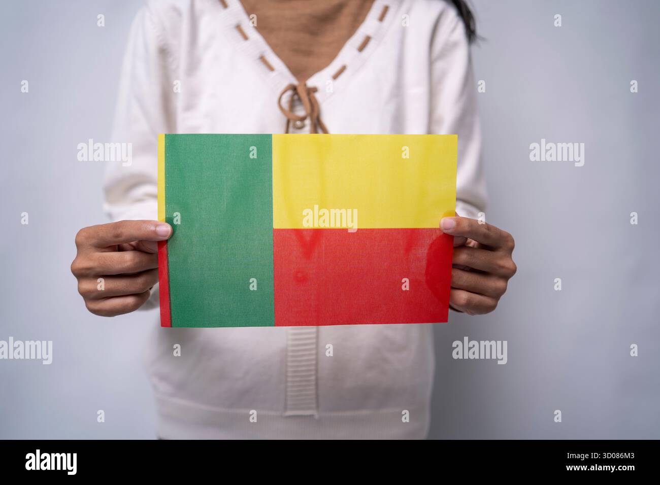 Une personne portant le drapeau du Bénin, symbole du patriotisme, de l'unité et de la fierté nationale Banque D'Images