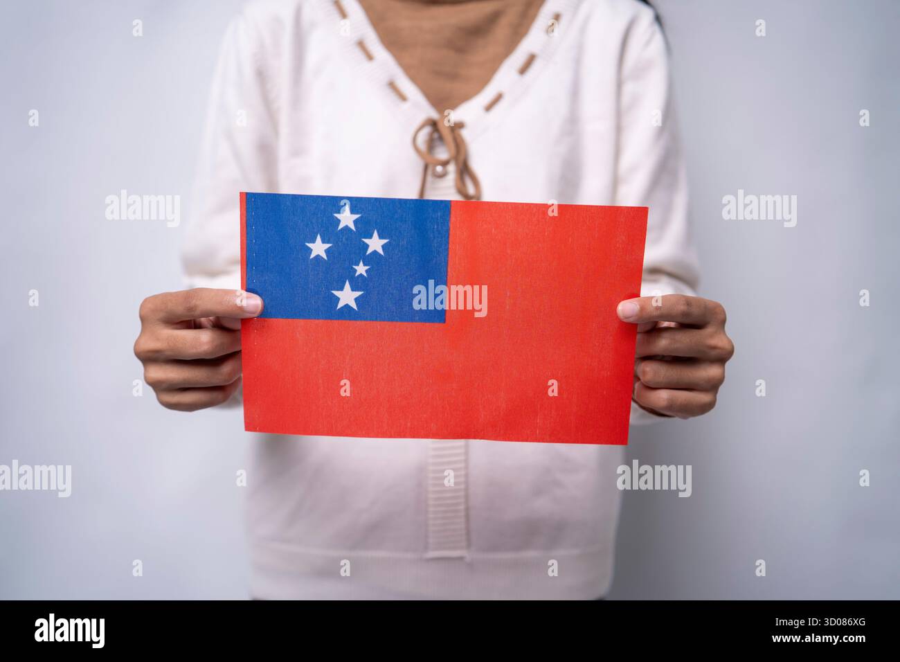 Une personne portant le drapeau du Samoa, symbole du patriotisme, de l'unité et de la fierté culturelle. L'image reflète l'amour pour la patrie et le respect pour Samoan Banque D'Images
