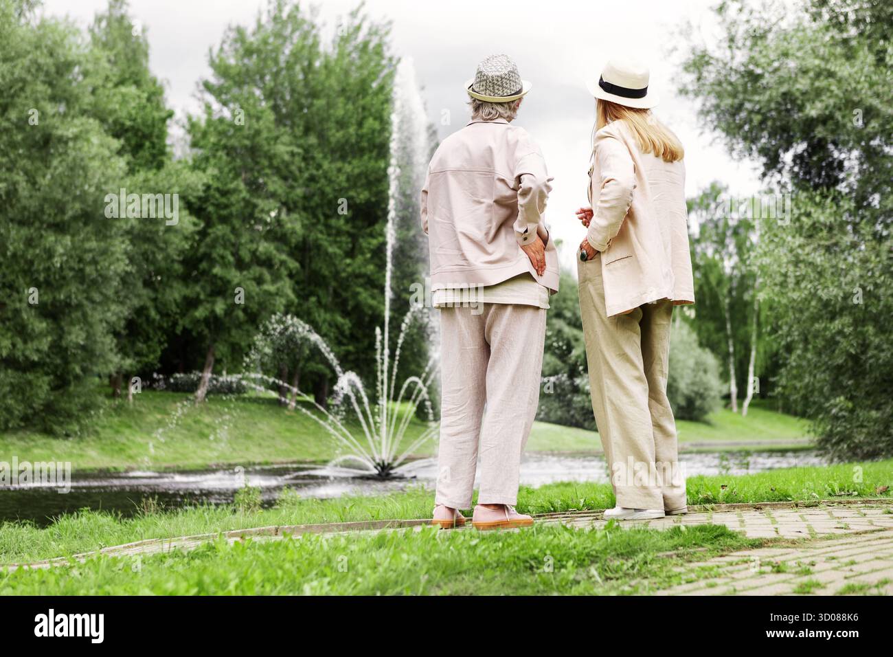 Deux femmes âgées debout sur toute la longueur dans le parc ensemble, admirant un beau paysage naturel et appréciant un mode de vie actif, l'amitié et le pois Banque D'Images