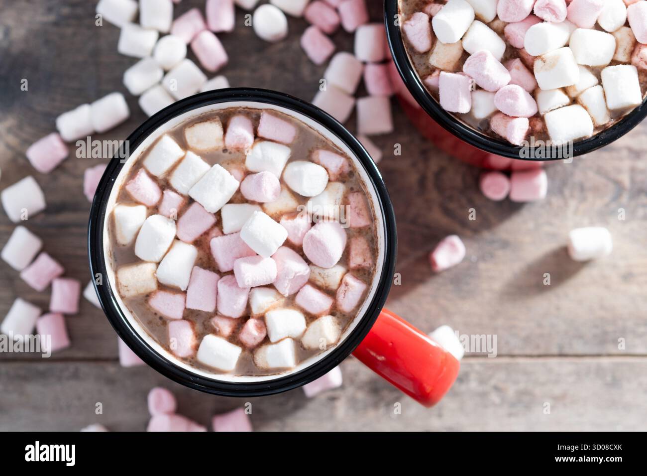 Boisson au chocolat chaud avec des guimauves dans une tasse rouge sur une table en bois Banque D'Images