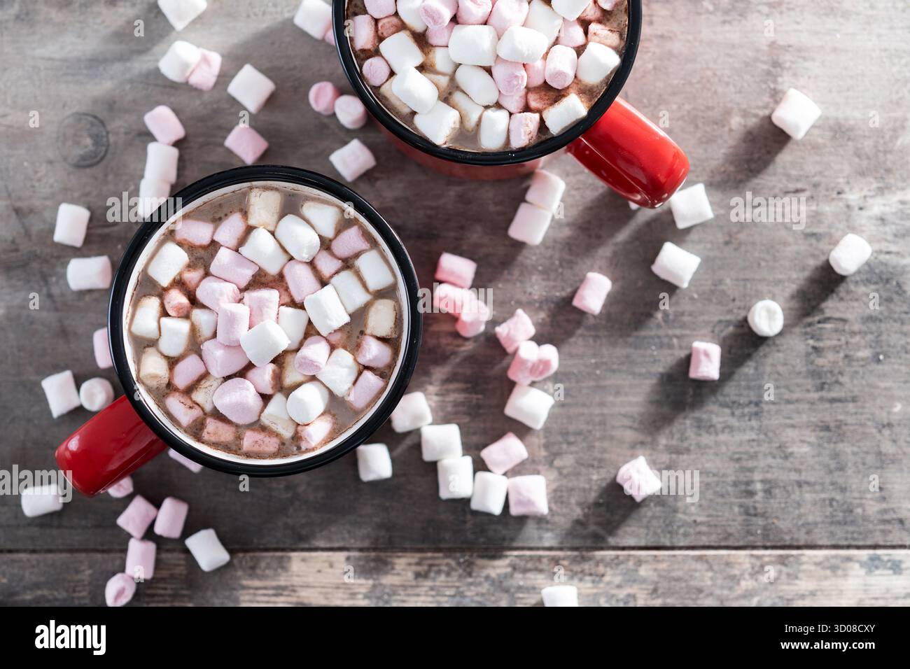 Boisson au chocolat chaud avec des guimauves dans une tasse rouge sur une table en bois Banque D'Images