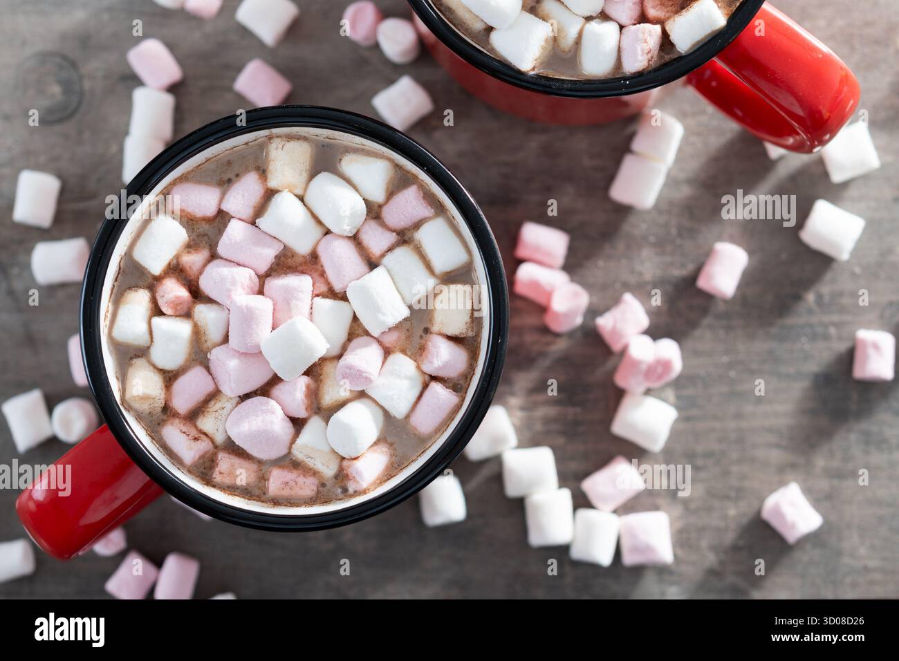 Boisson au chocolat chaud avec des guimauves dans une tasse rouge sur une table en bois Banque D'Images