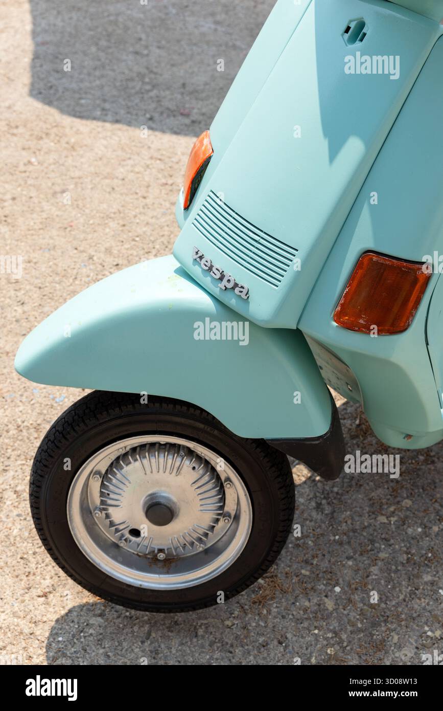 Istanbul, Turquie - 14 août 2025 : une Vespa turquoise rétro repose sur une surface de gravier, montrant son aile avant incurvée, ses lignes de calandre classiques et son tai orange Banque D'Images